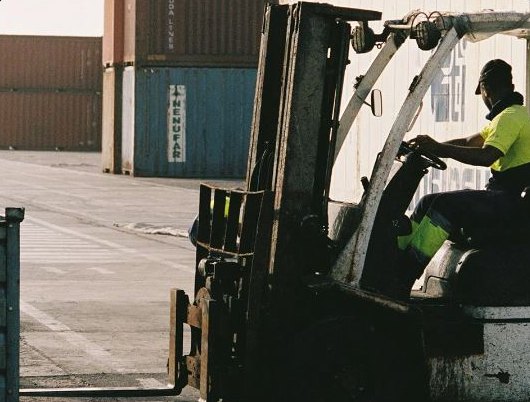 Forklift operator moving cargo in a container yard